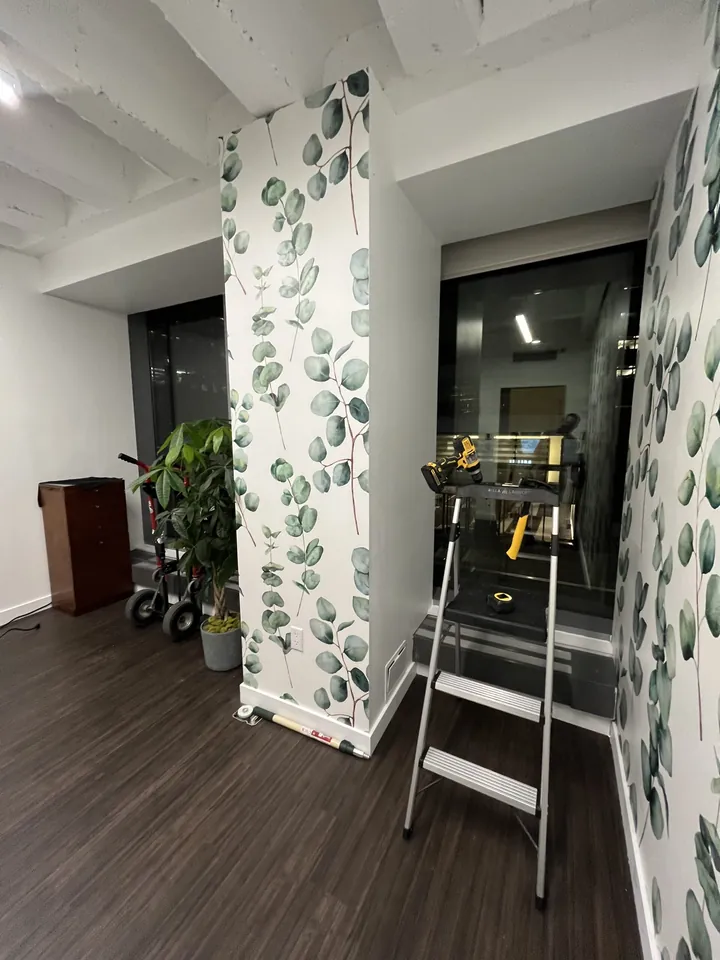 Wrapping a structural column in eucalyptus wallpaper during installation