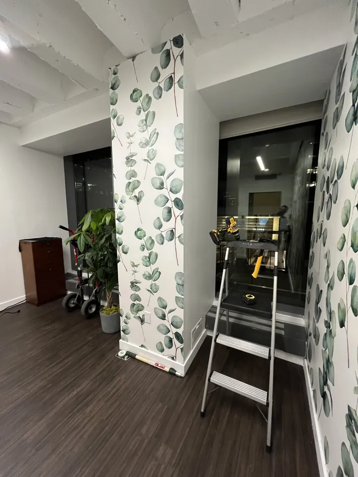 Salon walls wrapped in eucalyptus leaf wallpaper with city views at 59th Street Oasis