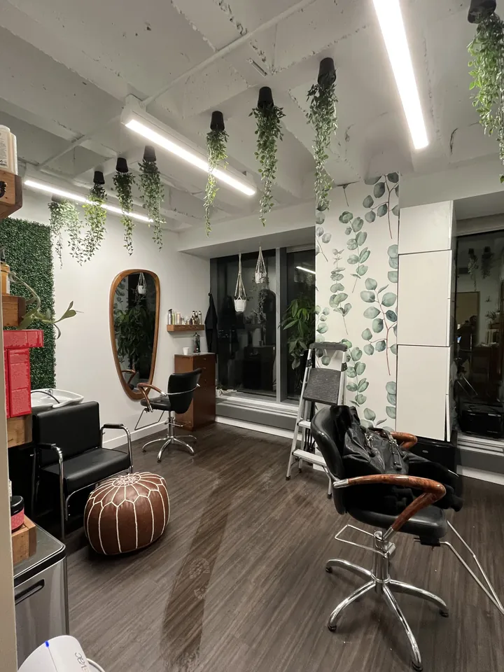 Upside-down hanging faux planters above salon chairs and mirrors