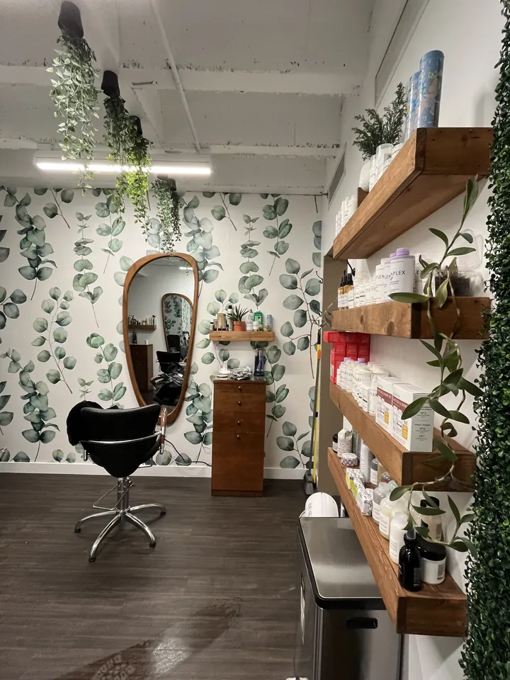 Salon product shelving and towels against eucalyptus wallpaper at 59th Street Oasis