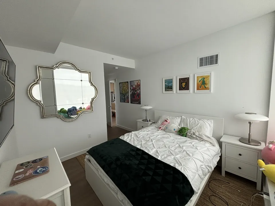 Bedroom styled with scalloped mirror, layered bedding and gallery art