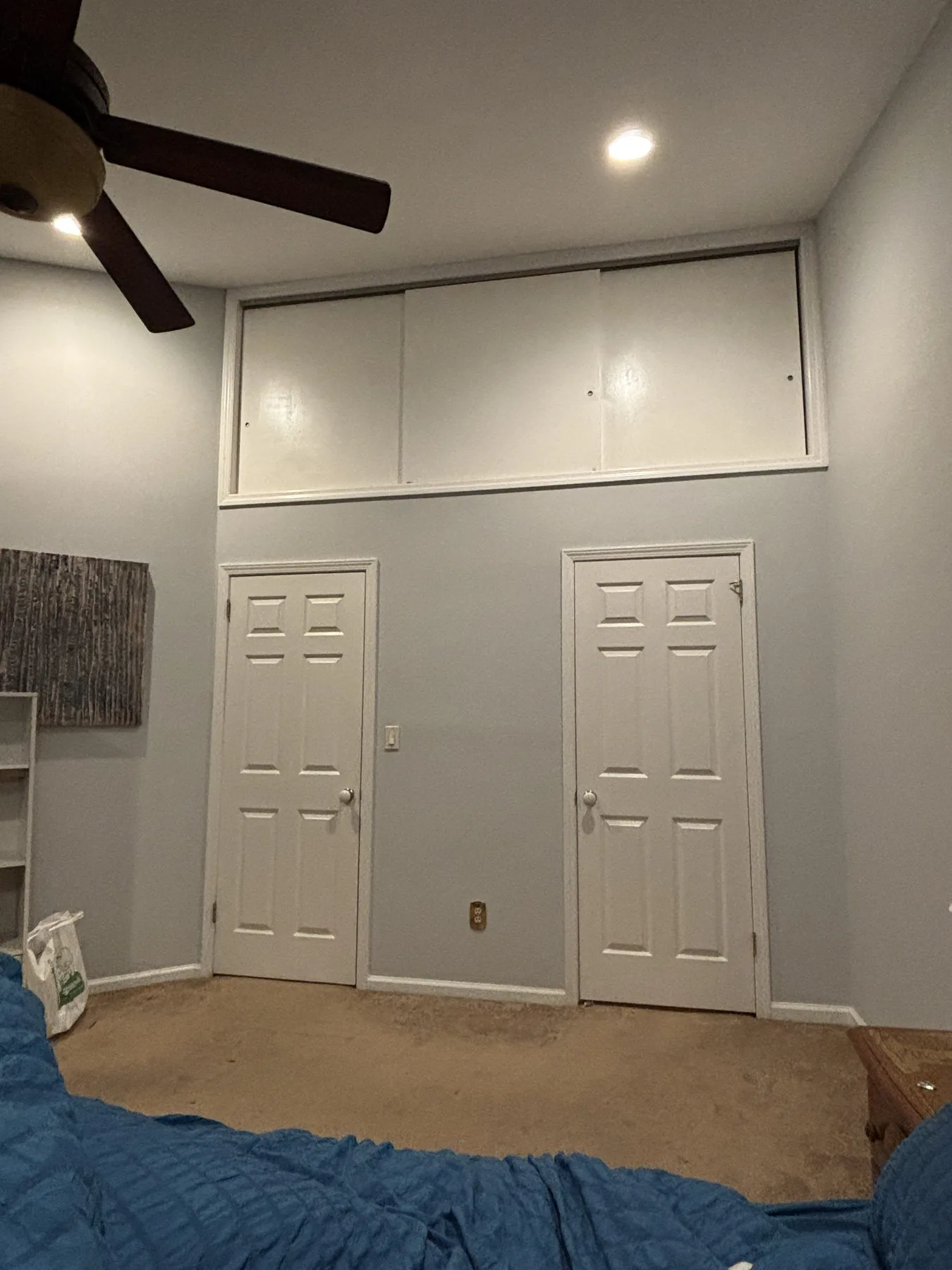 Finished loft closet cavity enclosure with sliding doors above closet