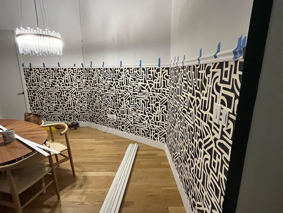 Side view of the bathroom vanity against geometric monogram wallpaper