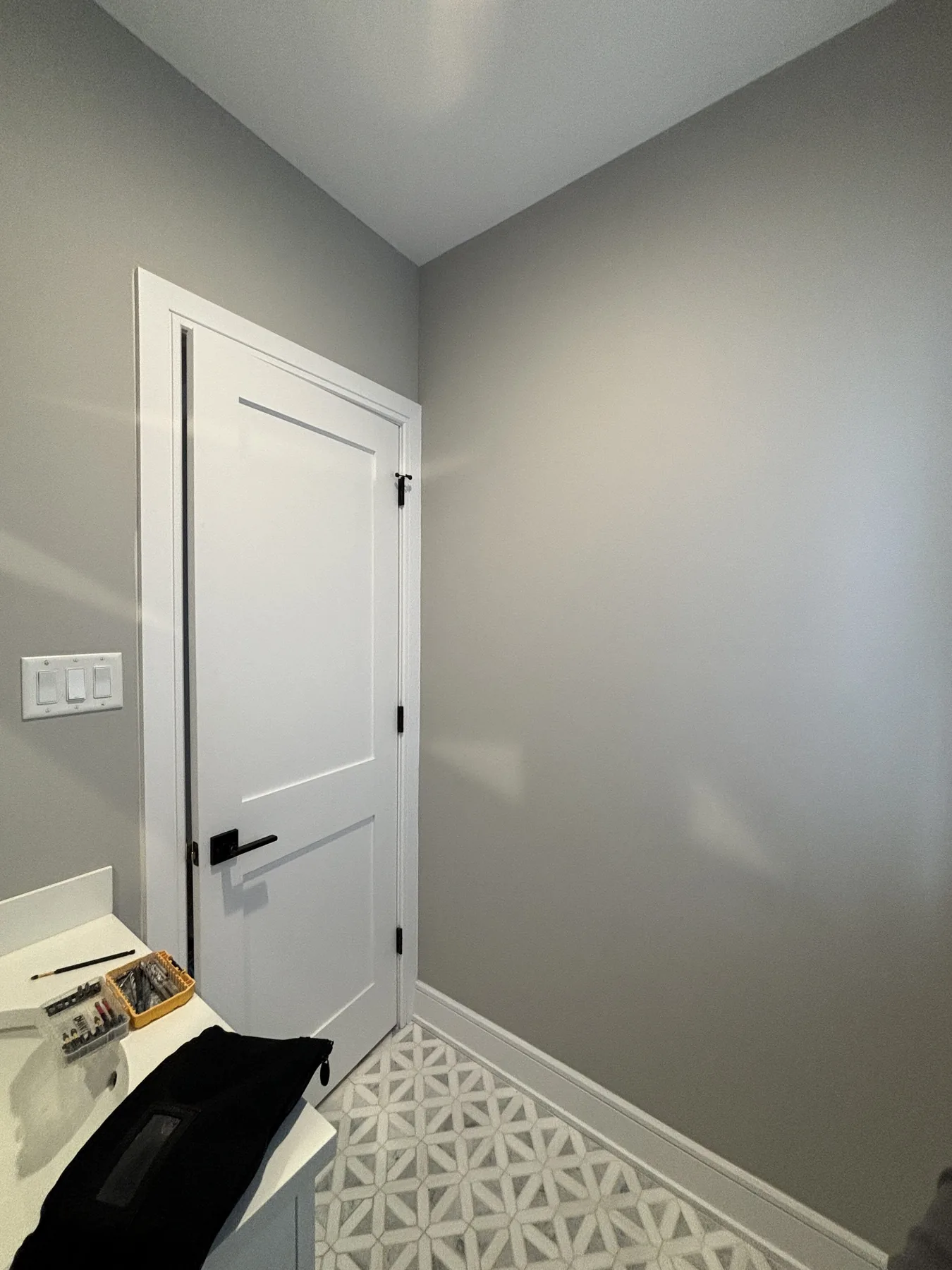 Powder room door angle with plain gray walls before wallpaper