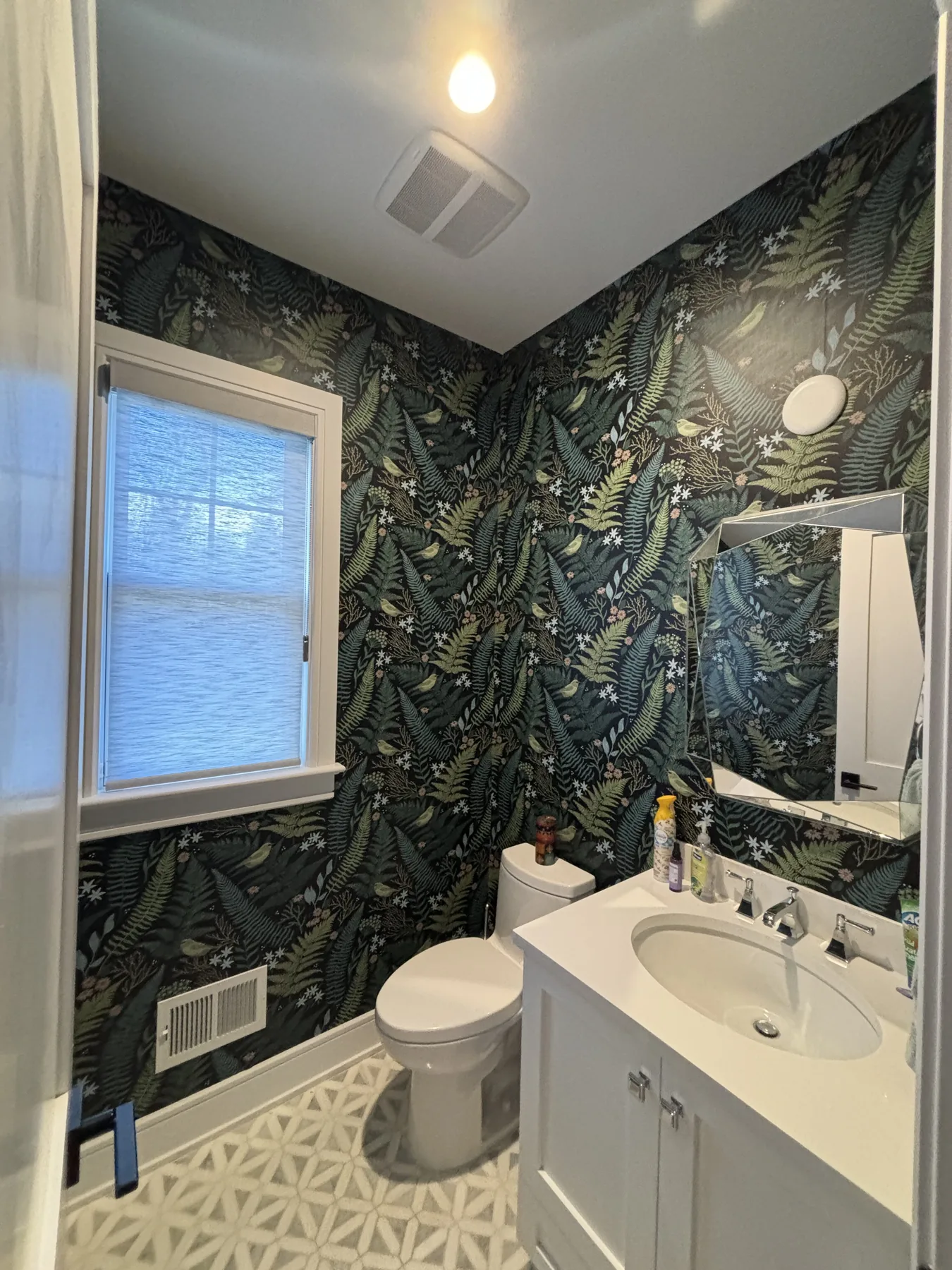 Powder room vanity angle wrapped in dark fern wallpaper