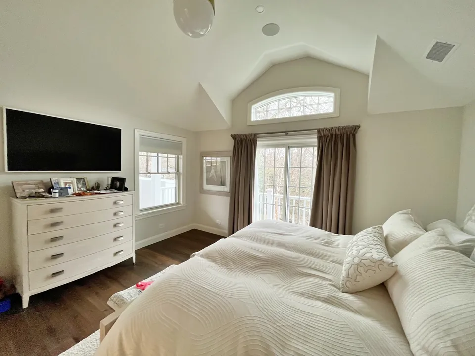 Bedroom media wall with mounted TV against cloud pattern wallpaper