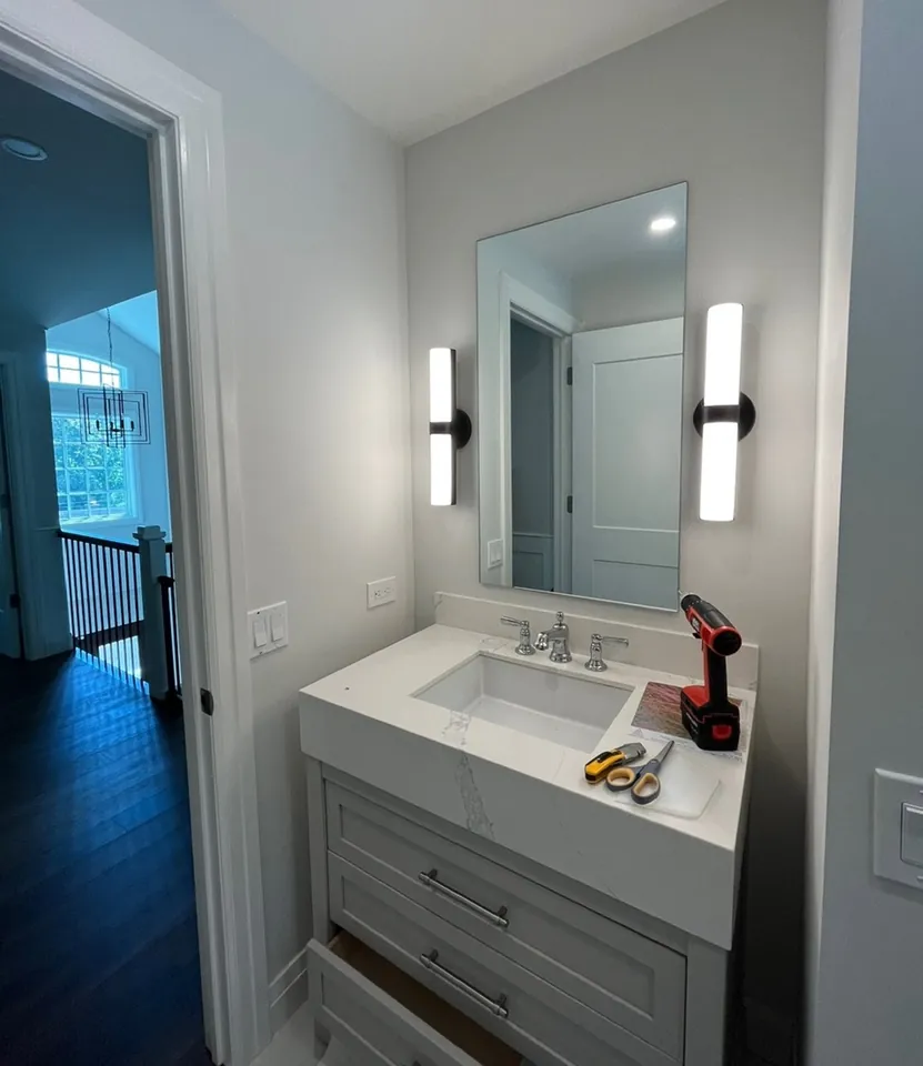 Grasscloth wrapped bathroom with vanity mirror and bilateral modern sconces