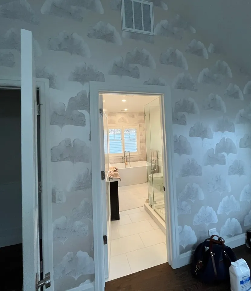 View from the primary bedroom into the wallpapered bathroom